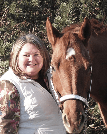 CEO Kelly Adams with a brown horse